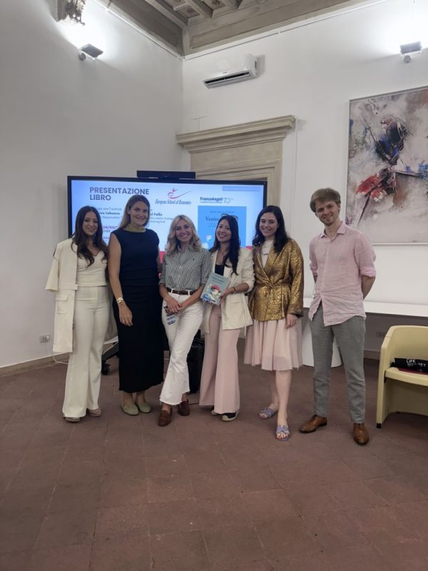 Foto de grupo de seis profesionales posando frente a la pantalla de presentación durante el lanzamiento del libro 