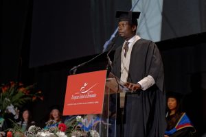 Oluwafemi offre la sua testimonianza durante la Cerimonia di Laurea ESE al Town Hall by Bottaccio, Londra.
