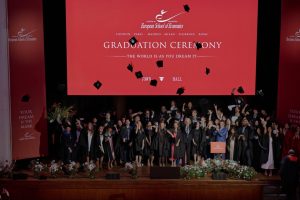 I laureati lanciano i cappelli sul palco al Town Hall by Bottaccio mentre familiari e amici catturano il momento — Cerimonia di Laurea ESE, 4 luglio 2026.