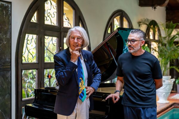 Il fondatore di ESE Elio D'Anna parla accanto a un pianoforte a coda con un relatore a ESE Milano.
