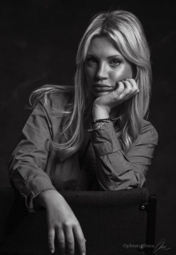Retrato en blanco y negro de Diletta apoyando la barbilla en la mano mientras se apoya en una silla.